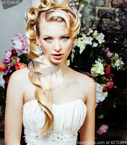 Image of beauty young blond woman bride alone in luxury vintage interior with a lot of flowers 