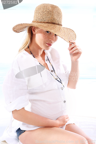 Image of Pregnant woman resting on the beach. 