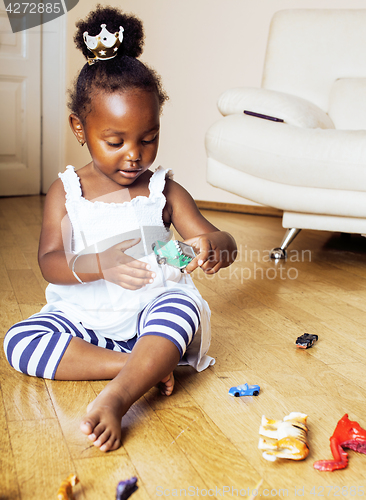 Image of little cute african american girl playing with animal toys at ho