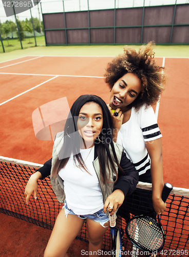 Image of young pretty girlfriends hanging on tennis court, fashion stylis