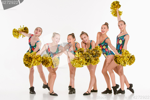 Image of The group of teen cheerleaders posing at white studio