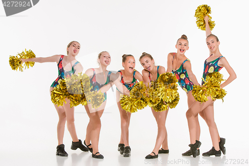 Image of The group of teen cheerleaders posing at white studio