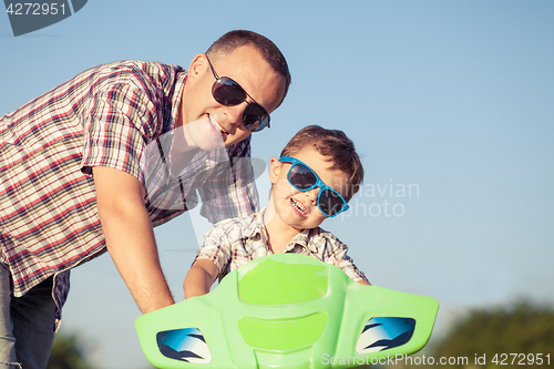 Image of Father and son playing on the road at the day time.