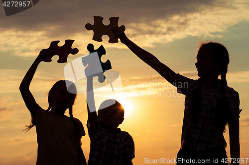 Image of Silhouette of happy people which playing on the beach at the sun