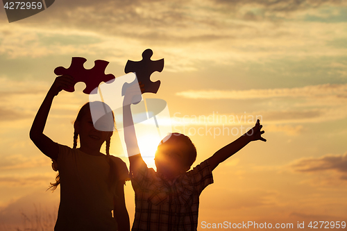 Image of Silhouette of happy people which playing on the beach at the sun