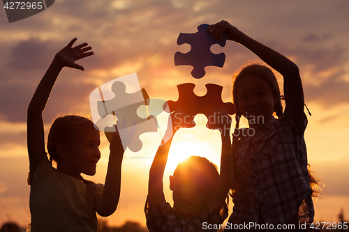 Image of Silhouette of happy people which playing on the beach at the sun