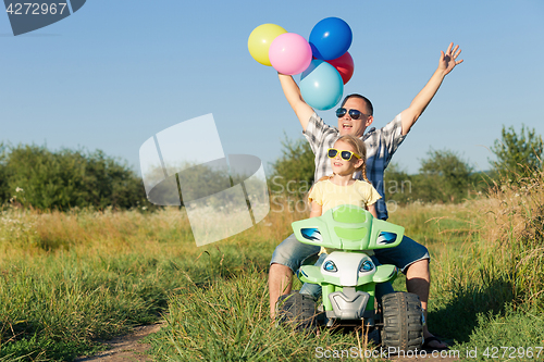 Image of Father and daughter playing on the road at the day time.