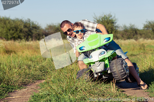 Image of Father and son playing on the road at the day time.