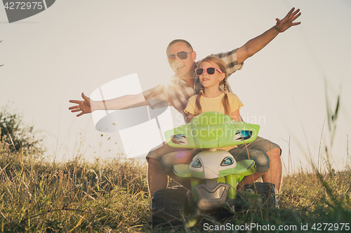 Image of Father and daughter playing on the road at the day time.