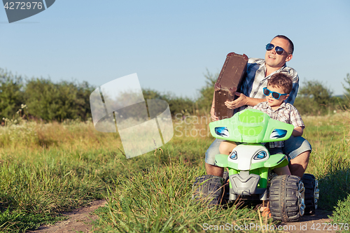 Image of Father and son playing on the road at the day time.