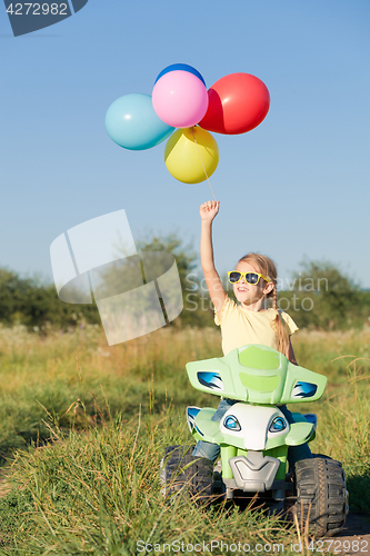 Image of Happy little girl playing on road at the day time.