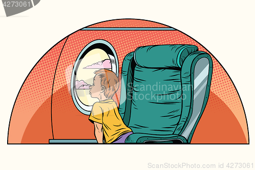 Image of Caucasian boy passenger looks out the window on an airliner