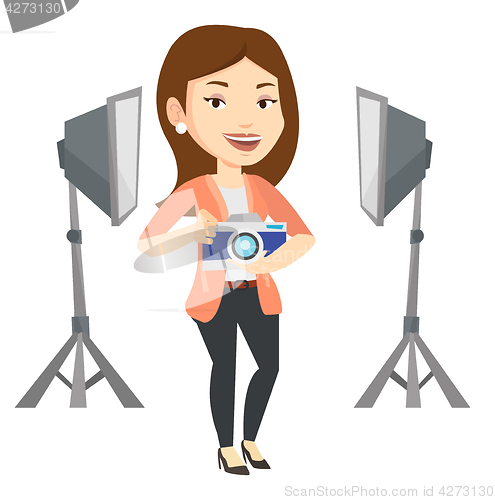 Image of Photographer with camera in photo studio.