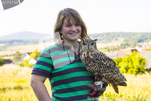 Image of Collared Scops Owl sitting on the hand of animal keeper