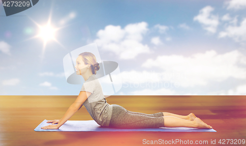 Image of woman making yoga in dog pose on mat