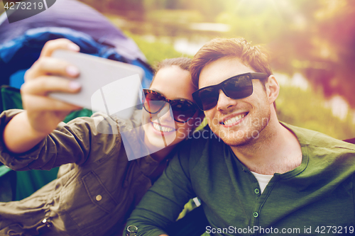 Image of couple of travelers taking selfie by smartphone