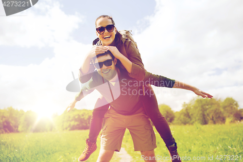 Image of happy couple with backpacks having fun outdoors