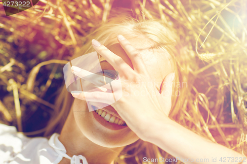 Image of happy young woman lying on cereal field