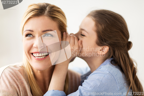 Image of happy girl whispering secret to her mother