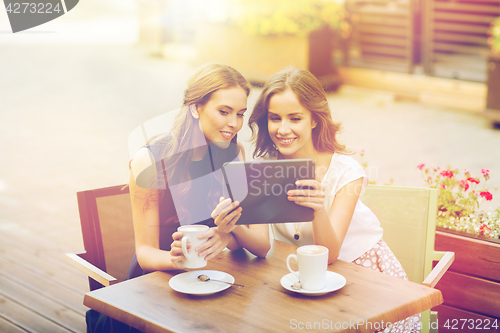 Image of young women with tablet pc and coffee at cafe