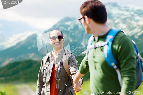 Image of happy couple with backpacks traveling in highlands