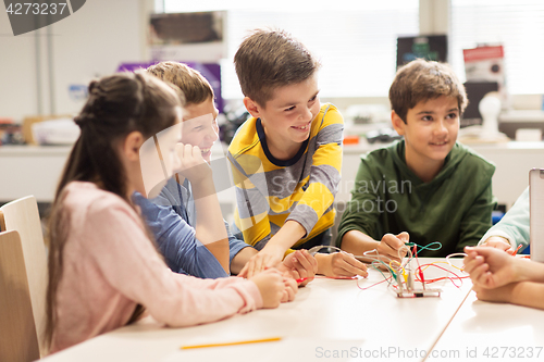 Image of happy children building robots at robotics school