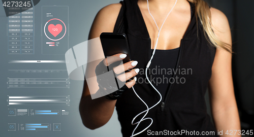 Image of sportswoman with smartphone and earphones