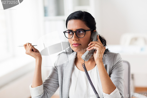 Image of businesswoman calling on phone at office