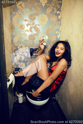 Image of pretty young african american woman in luxury restroom with mone
