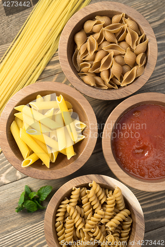 Image of Variety of Pasta Wooden Bowls Cutting Boards Marinara Sauce