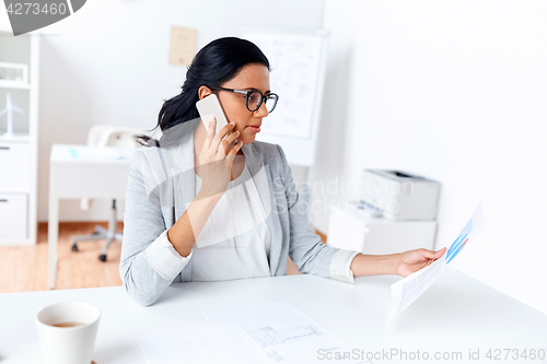 Image of businesswoman calling on smartphone at office