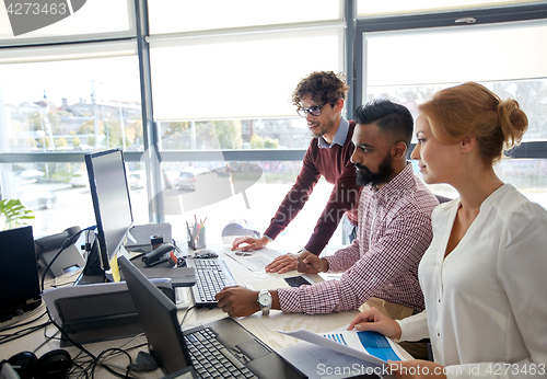 Image of business team with computers and papers at office
