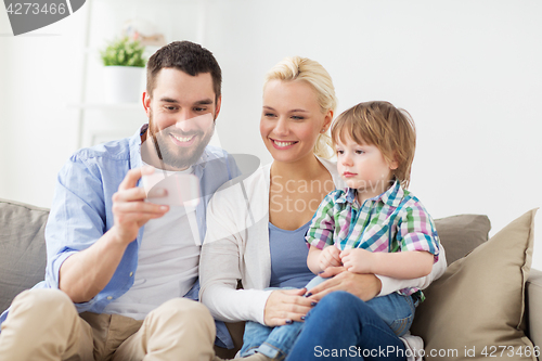 Image of happy family with smartphone at home