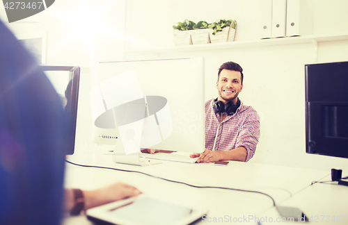 Image of creative man with headphones and computer