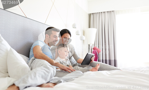 Image of happy family with tablet pc in bed at home