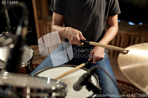 Image of male musician playing drums and cymbals at concert