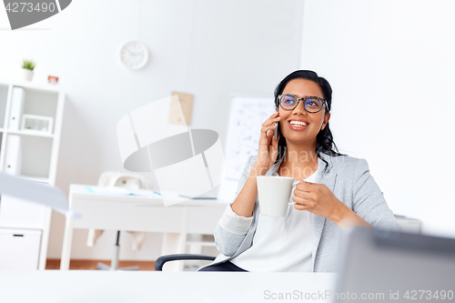 Image of businesswoman calling on smartphone at office