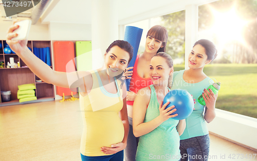 Image of pregnant women taking selfie by smartphone in gym
