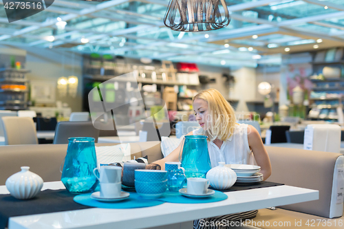 Image of Woman choosing the right decor for her apartment in a modern home furnishings store.