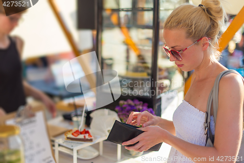 Image of Woman buying meal at street food festival.