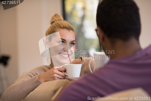 Image of Young multiethnic couple  in front of fireplace