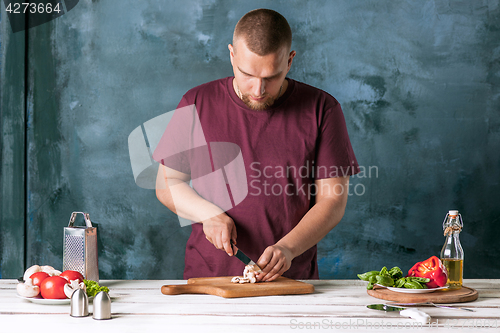 Image of Closeup hand of chef baker making pizza at kitchen