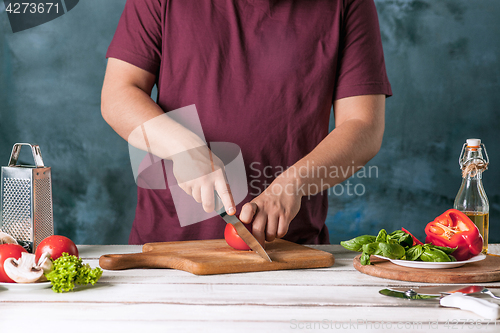 Image of Closeup hand of chef baker making pizza at kitchen