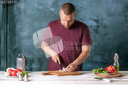 Image of Closeup hand of chef baker making pizza at kitchen