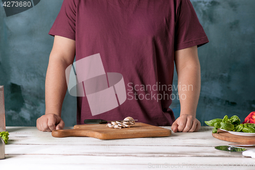 Image of Closeup hand of chef baker making pizza at kitchen