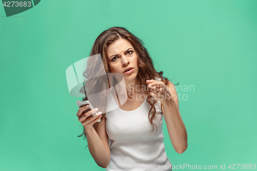 Image of The portrait of disgusted woman with mobile phone