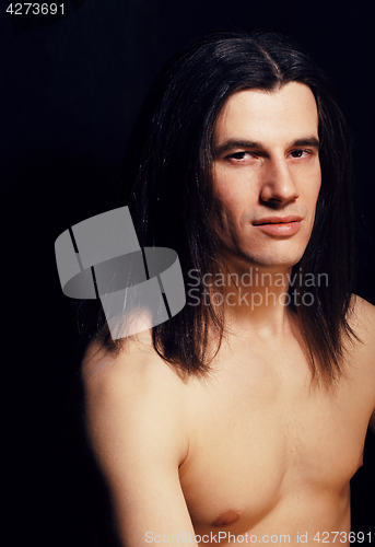 Image of handsome young man with long hair naked torso on black backgroun