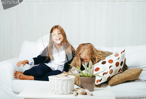 Image of two cute sisters at home playing, little girl in house interior 