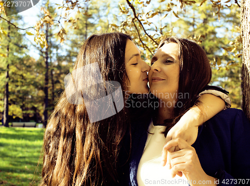 Image of mature real mother with daughter outside autumn fall in park