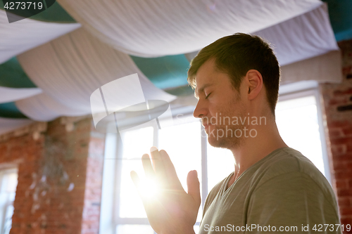 Image of close up of man meditating at yoga studio